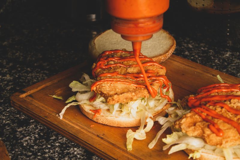 Hangry Joe's hot chicken sandwich stacked high with pickles and sauce